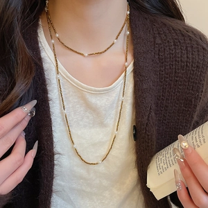 Close-up of vintage beaded pearl necklace on model with bronze metal beads and white pearls