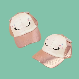 Cute kids pink baseball cap with 3D ears and glittery stars on mint green backdrop