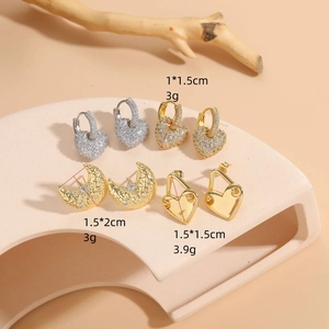Selection of gold heart and moon zircon earrings displayed on a minimalist stand
