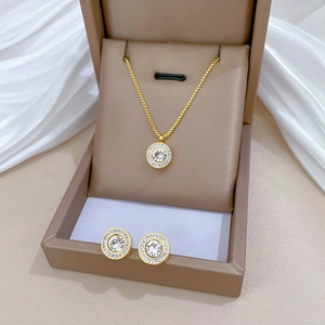 Macro view of gold plated titanium necklace and stud earrings set with sparkling crystals
