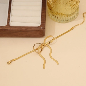 Elegant gold snake chain necklace featuring a polished bow pendant and adjustable clasp
