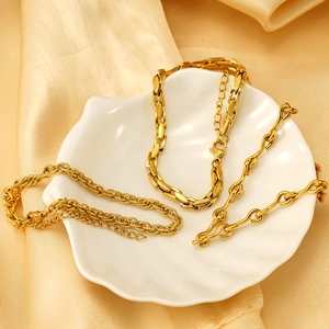 Three gold plated titanium steel anklet set with figaro and rope chain styles on silk