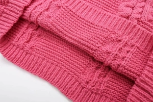 Close-up of the rose red knit sweater showing detailed texture of the ribbed hemline