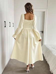Back view of elegant long-sleeve cream dress with square neck and flared A-line skirt