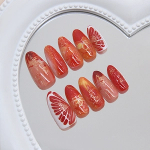 Glossy red press-on nails with fine glitter, hand-painted floral designs and gold foil