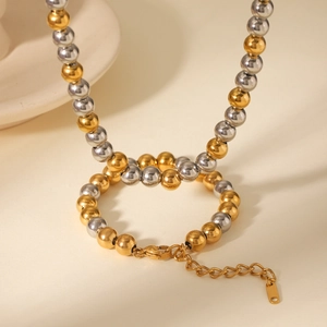 Détails d'un ensemble collier et bracelet en perles bicolores dorées et argentées