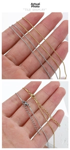 Detailed view of gold and silver snake chain necklaces with lobster clasp and extender