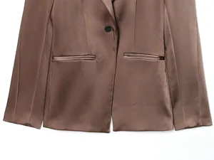 Detail of brown satin blazer featuring a single button closure and twin welt pockets