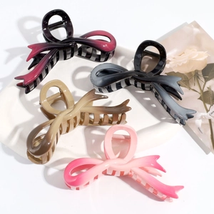 Close-up of four gradient butterfly hair claws in burgundy, brown and pink resin colors