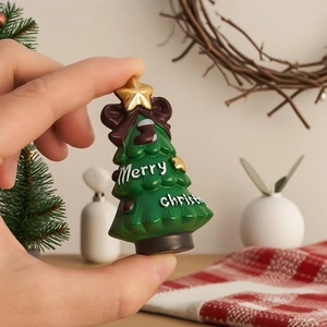 Detailed view of mini Christmas tree ornament with golden star and brown bow decoration