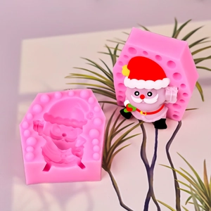 Pink silicone mold with finished Santa Claus figurine for candle making and baking crafts