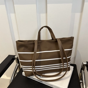 Brown striped canvas tote bag with dual straps on a chair, minimalist large capacity shoulder bag
