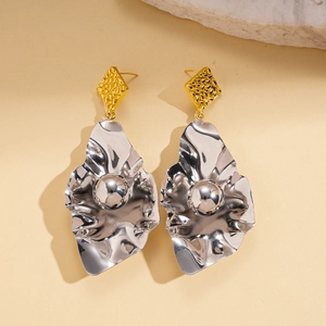 Macro detail of irregular leaf geometric earrings with hammer texture and metallic finish
