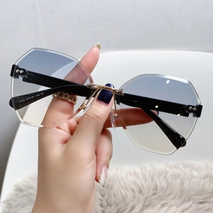 Detail of rimless butterfly sunglasses with blue gradient lenses and gold metal bridge