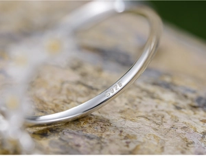 Detailed macro shot of S925 sterling silver hallmark engraving on minimalist ring surface