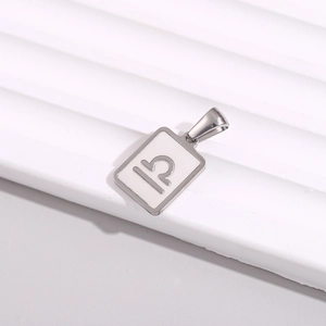 Macro detail of silver rectangle pendant featuring white enamel and Libra zodiac symbol