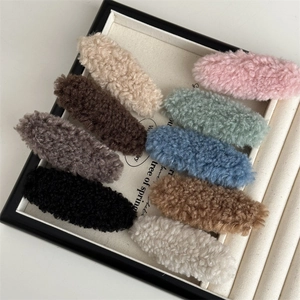 Detailed view of nine colorful plush lamb wool hair clips neatly arranged in a display tray