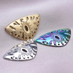 Macro shot of triangle eye pendants in gold, silver and rainbow colors for DIY jewelry