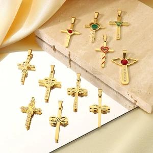 Détail de pendentifs croix en or 18k avec pierres précieuses sur soie et pierre