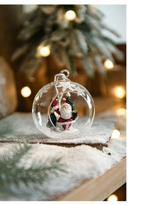 Detail of clear Christmas glass ball with miniature Santa Claus and snow tree scenery