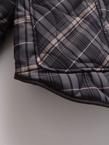 Gros plan détaillé de la veste matelassée française en coton à carreaux gris et rose doux