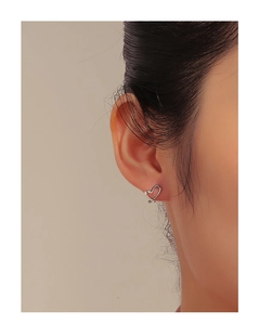 Close-up of irregular hollow heart stud earrings in polished S925 sterling silver
