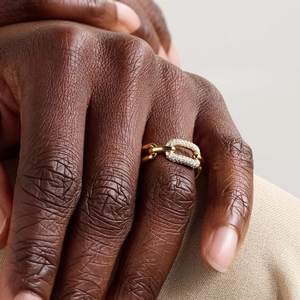 Detailed close-up of a 18K gold-plated chain ring with sparkling zircon stones on finger