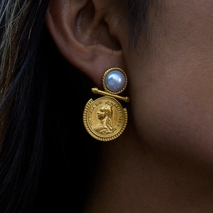 Macro shot of gold coin earring with white pearl and Victoria D G engraving detail