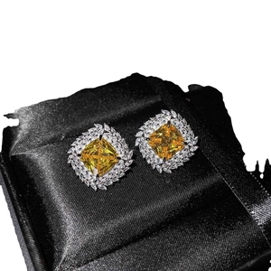 Luxury square yellow gemstone stud earrings with white diamond halo on black velvet cushion