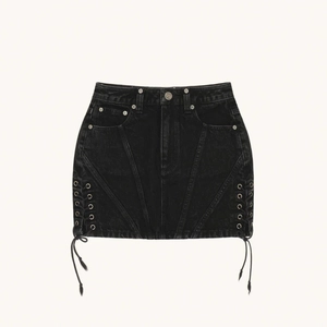 Détail d'une mini-jupe en jean noir avec rivets métalliques et laçage latéral ajustable