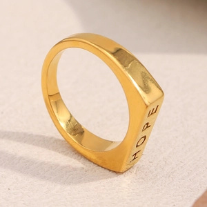 Nahaufnahme des vergoldeten Edelstahlrings mit HOPE-Gravur in minimalistischem Stil