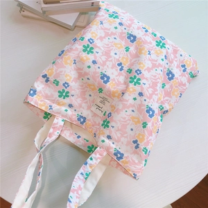 Flat lay macro shot of floral cotton tote bag with pink flower pattern and canvas strap