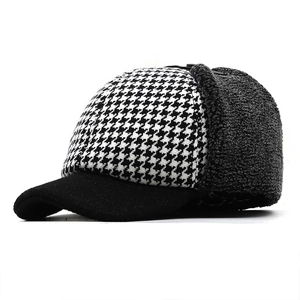 Detail of winter baseball cap with houndstooth pattern and warm fleece ear flaps