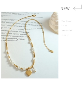 Detailed view of handmade pearl necklace with gold heart pendant and K18 metal tag