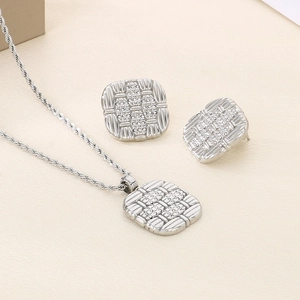 Detailed view of silver jewelry set with square woven texture necklace and earrings