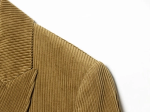 Detailed close-up of brown corduroy blazer fabric showing collar and texture