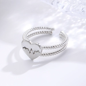 Detailed view of adjustable silver heart ring with twisted rope band and heartbeat engraving