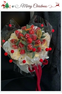 Detail of Christmas strawberry bouquet with pine branches, cinnamon sticks and red pompons