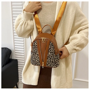 Detail of leopard print mini backpack featuring double zippers and a wide shoulder strap