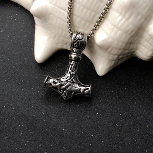 Close-up of vintage silver Viking Mjölnir pendant with intricate Nordic engravings