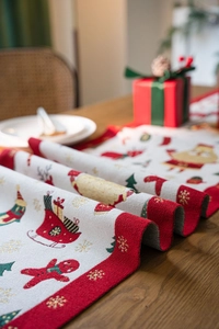 Macro detail of Christmas jacquard table runner showing gingerbread and santa motifs