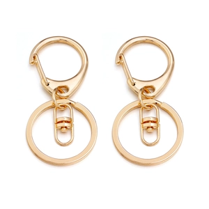 Macro detail of two golden D-shaped lobster clasp keychains with premium alloy finish