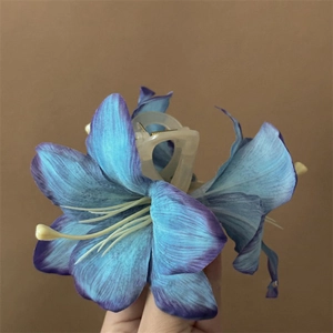 Detail of blue lily hair claw clip with delicate fabric petals and realistic yellow stamens
