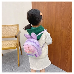 Detail of a purple kids backpack with sequin rabbit ears and a large pink tulle bow