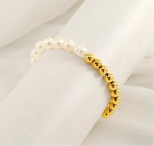 Détail du bracelet en perles d'eau douce et billes dorées sur un support blanc élégant