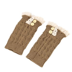 Close-up of brown cable knit leg warmers with beige lace trim and button detail