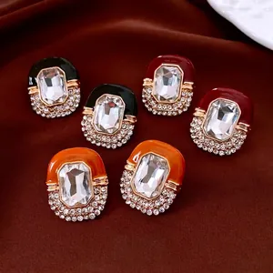 Vintage palace style oval earrings with diamonds and enamel inlay on red silk background
