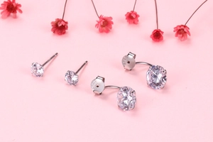 Close-up of S925 sterling silver earrings with clear cubic zirconia on pink background