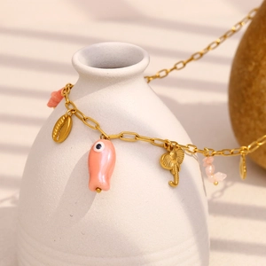 Detail of pink shell fish and natural stone pendants on an 18K gold-plated paperclip chain