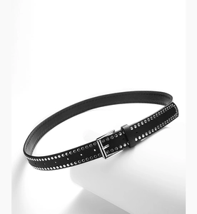 Detail view of black PU leather belt with silver metal rivets and classic pin buckle